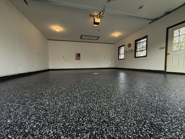 Garage with black-and-white epoxy coated concrete floor and finished walls